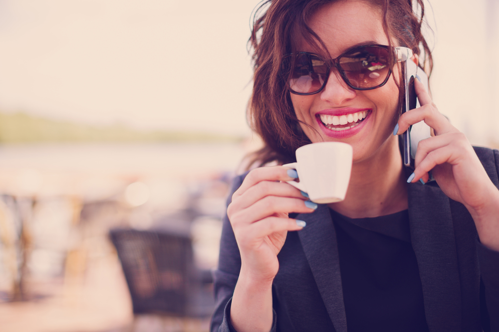 Young,Woman,At,Cafe,Drinking,Coffee,And,Talking,On,The
